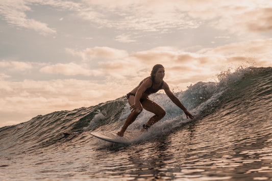 Surferin beim Surfen <a href="https://www.magnific.com/free-photo/woman-surfing-mentawai-islands-sumatra-indonesia_12305441.htm">Image by wirestock on Magnific</a>