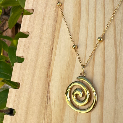 Detailaufnahme des goldenen Spiral-Anhängers aus Edelstahl mit Kugelkette
